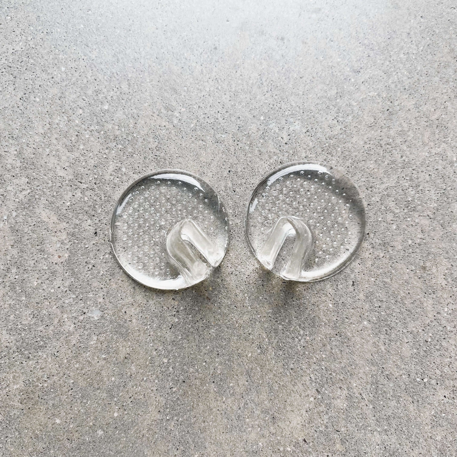 A pair of toe protectors are sitting side by side on a grey background.