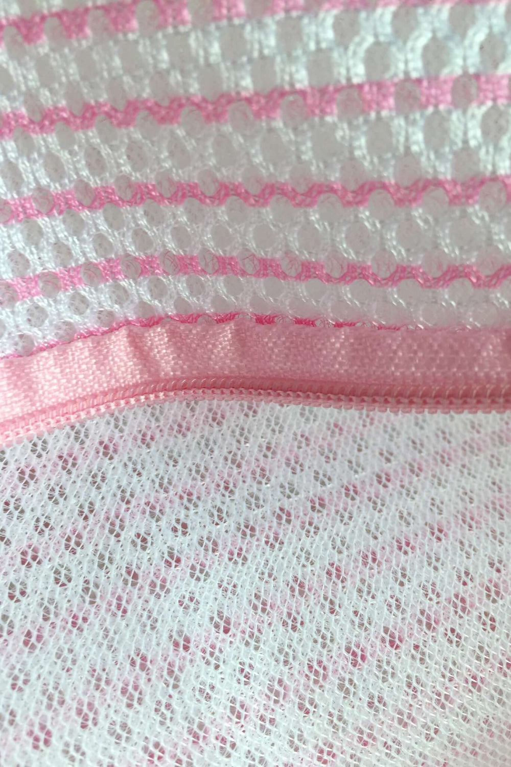 a close up photo of pink Lingerie Wash Bag from secret weapons, highlighting double mesh and smooth zipper for durability