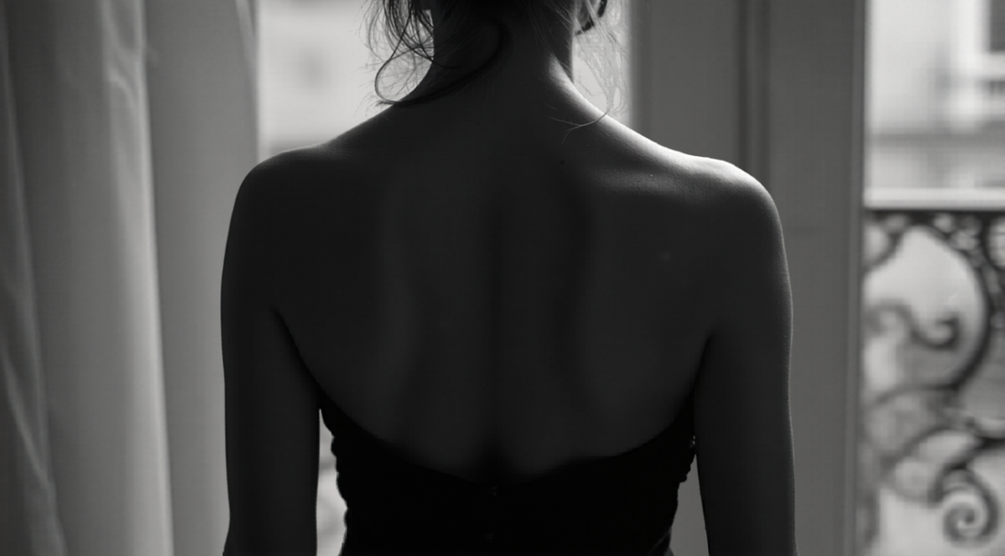 Black and white editorial photograph of a woman wearing an elegant strapless dress, classic monochrome lifestyle imagery.