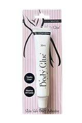 A tube labeled "Body Glue" in sleek packaging, featuring text: "30ml," "Totally Clear," "Washes Off Easily," over a pink and white striped backdrop. Described as "Skin Safe Body Adhesive."