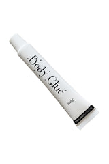 A white tube labeled "Body Glue, 30ml" lies diagonally against a plain background. The cap is on, and it includes branding "SECRETWEAPONS" near the base.