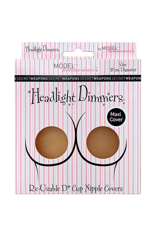 Package with two beige nipple covers, labeled "Headlight Dimmers" by Model Behaviour, on pink-striped background. Text: "Re-Usable D+ Cup Nipple Covers," "Maxi Cover," and "Size 10cm Diameter."