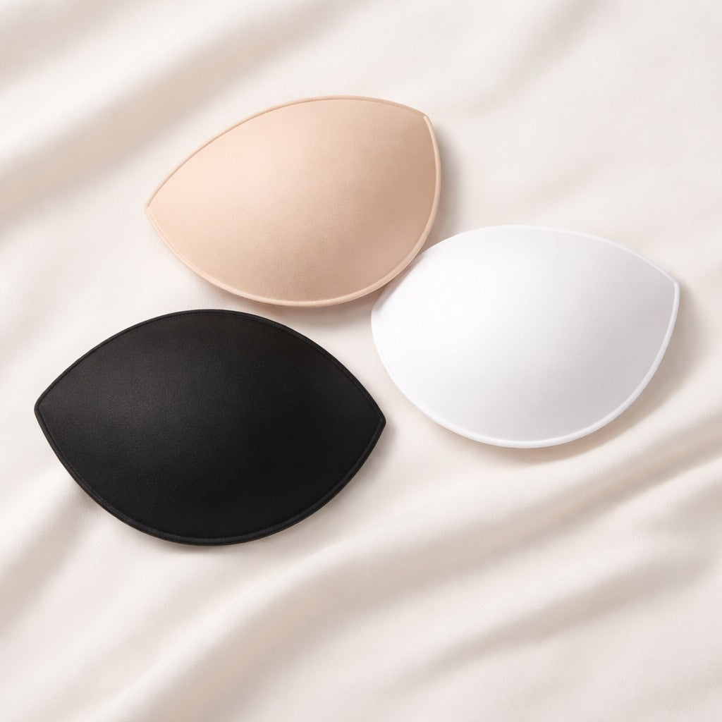 Three Sports Bra Insert Bra Pads in colours nude, black and white on a natural background