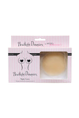 Nipple covers in a pink-striped box labeled "Headlight Dimmers" by Model Behaviour. The packaging features heart-shaped illustrations and text: "They go unnoticed to ensure you won't!"