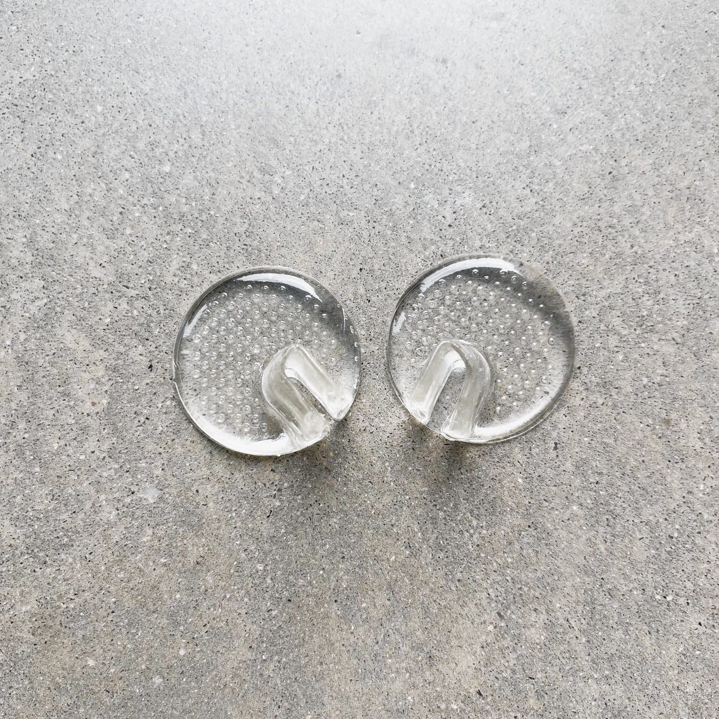 A pair of toe protectors are sitting side by side on a grey background.