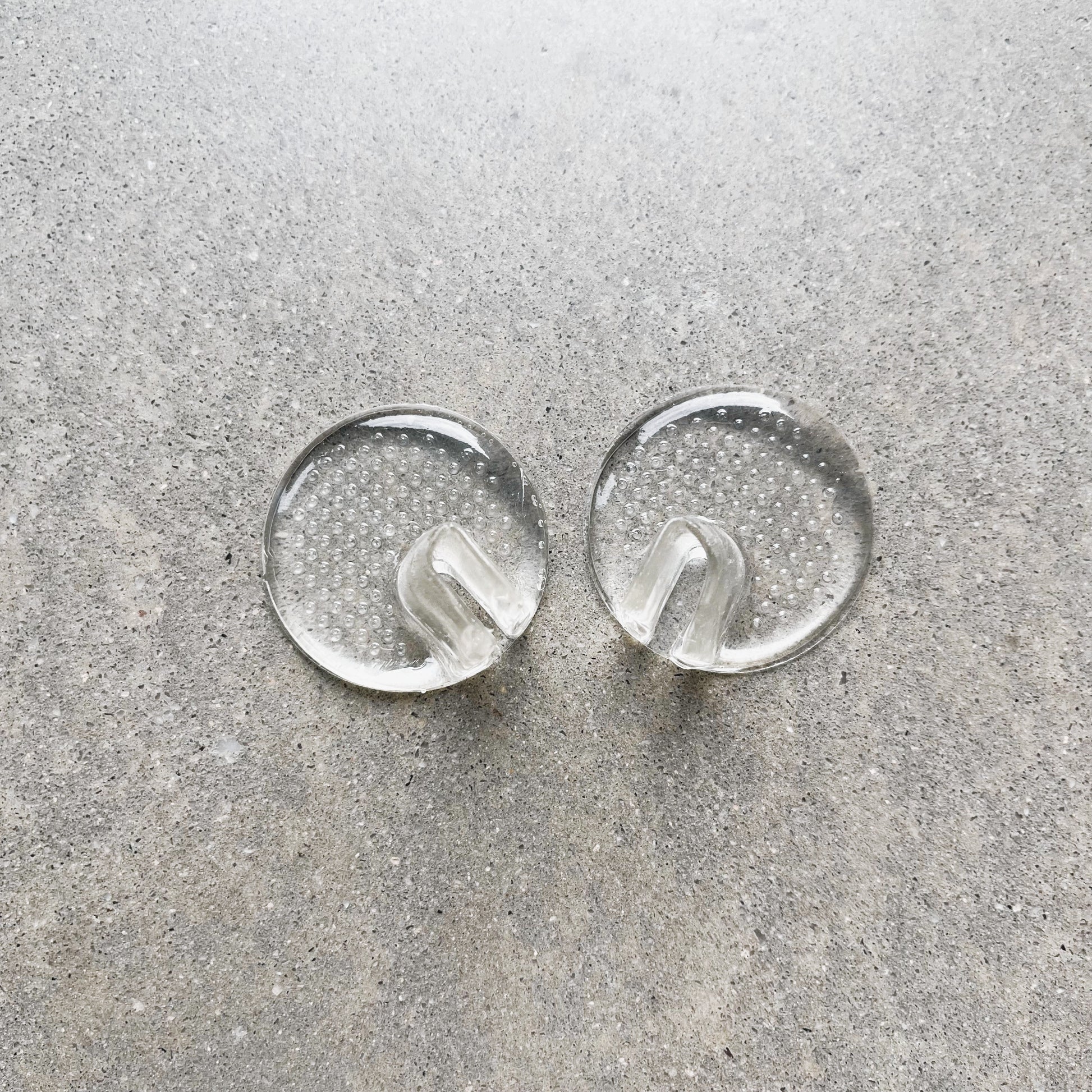 A pair of toe protectors are sitting side by side on a grey background.
