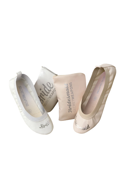 Two pairs of foldable ballet flats with carry purse on a white background.One pair of white fold up ballet flats showing BRIDE embellishment on white ballet flat shoes and BRIDESMAID embellishment on nude colour fold up ballet flat shoes