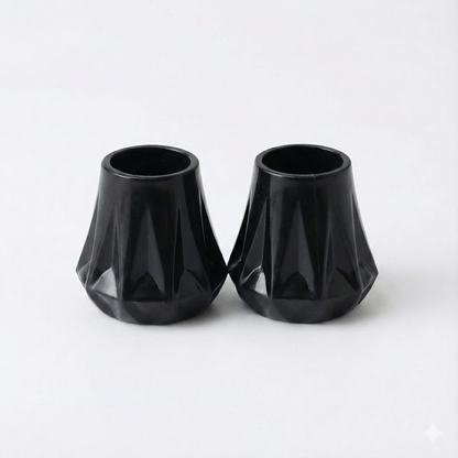 two black heel protectors showing the universal fitting system on a white background