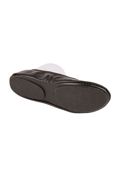 The sole of a pair of black fold up ballet flat shoes against a white background.  