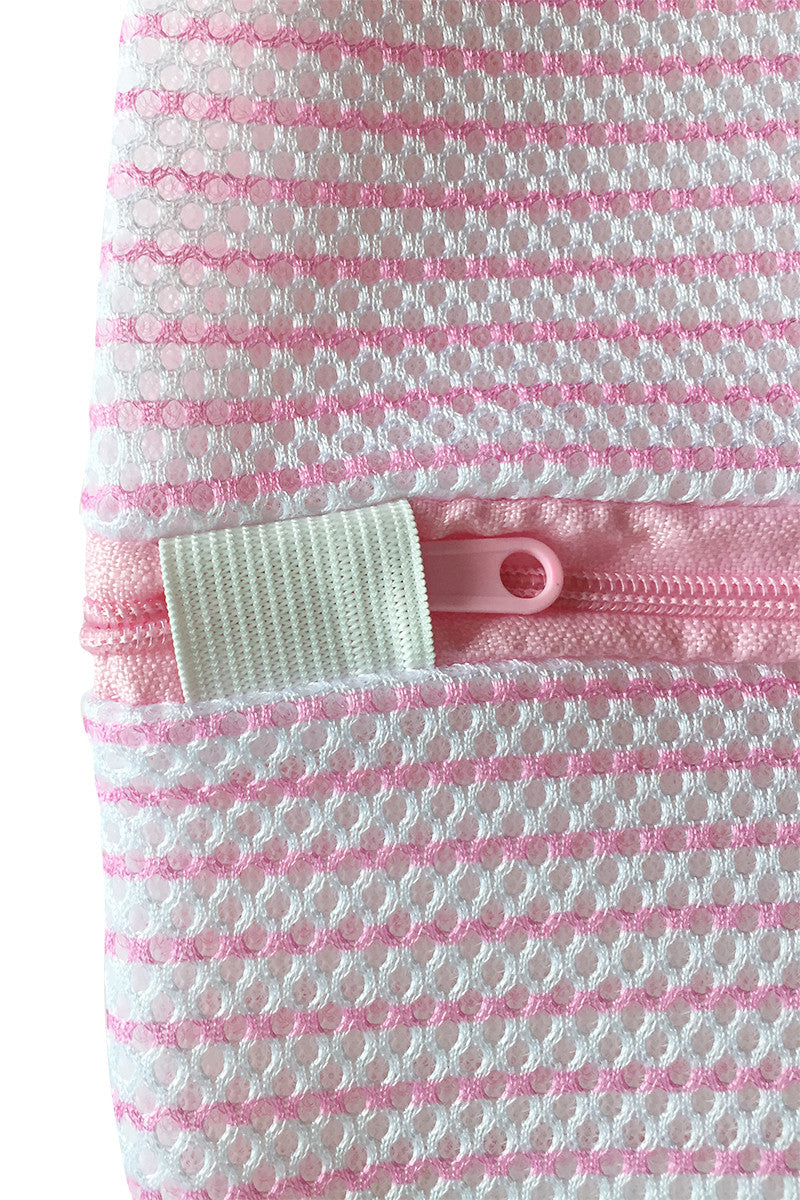 A pink and white textured fabric with a visible zipper partially open, features a small white elastic loop attached, filling the image frame with no surrounding context.