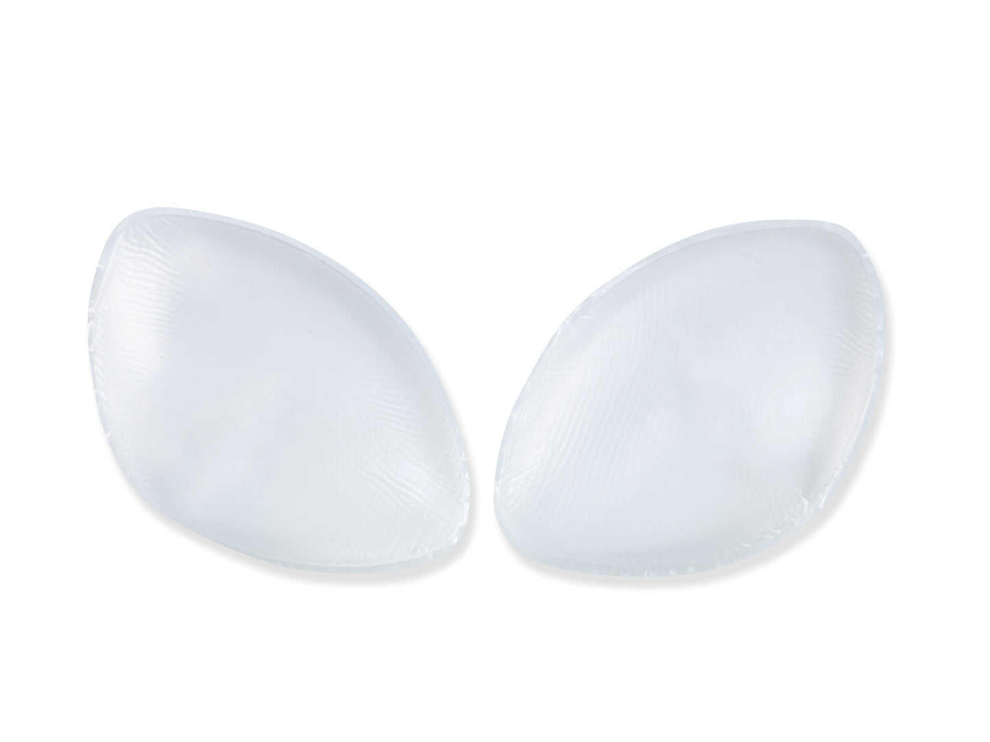 Two transparent silicone pads rest against a plain white background, appearing smooth and slightly convex, typically used for cushioning or support in garments or shoes.